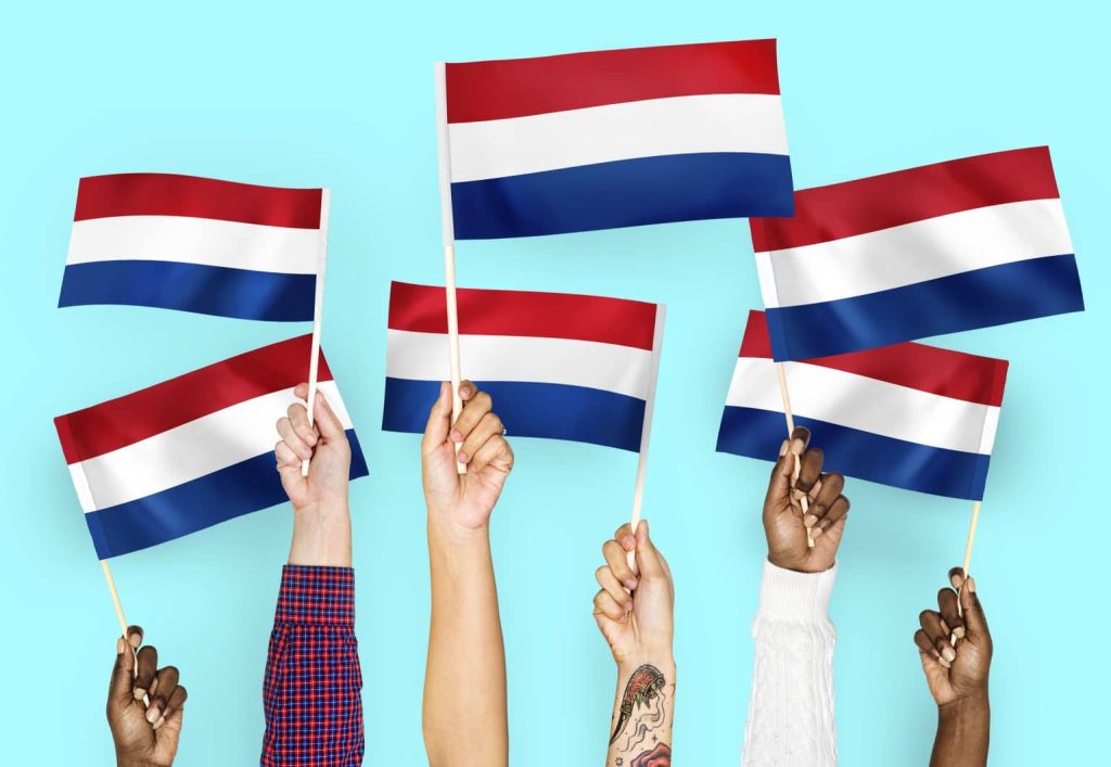 Personen die vlaggetjes omhoog houden.
